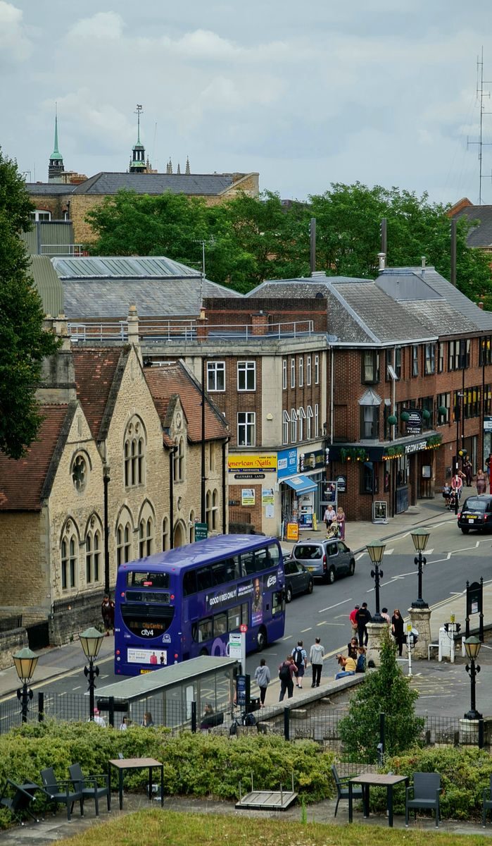 Vibrant street scene in Oxford, England with a classic double decker bus and historic architecture.